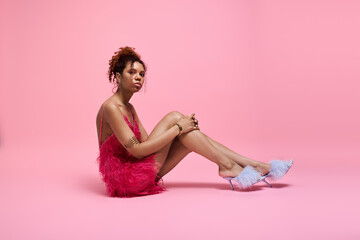 Naklejka premium Young woman in vibrant pink outfit exudes confidence and style in a pastel setting