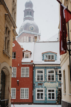Snowy Old Town Street in Riga, Latvia with Riga Cathedral Dome in Background