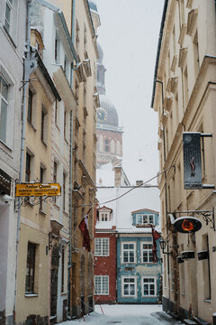 Snowy Old Town Street in Riga, Latvia with Riga Cathedral Dome in Background