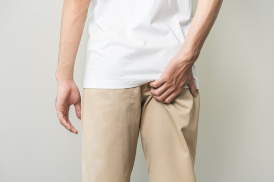 Closeup annoying itch asian man with an itchy his butt from fungal, male scratching crotch with hand, itching groin, male suffering body problem. Health care, hygiene, skin disease, medicine concept