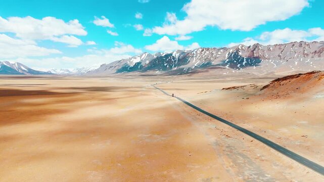 4K aerial shot of More Plains on the Leh-Manali Highway. Vehicles driving along asphalt highway road passing through mountains in Ladakh, India. Adventure and travel background. Summer road trip. Aeri