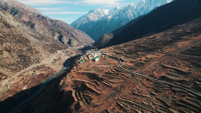 4K aerial view of Triloknath village which is build on cliff of mountain at Lahaul, Himachal Pradesh, India. Small village in Himalaya mountains with flowing Chenab river in beautiful valley. mountain