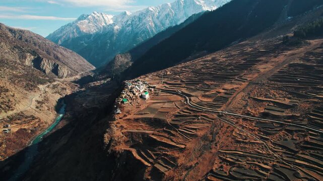 4K aerial view of Triloknath village which is build on cliff of mountain at Lahaul, Himachal Pradesh, India. Small village in Himalaya mountains with flowing Chenab river in beautiful valley. mountain
