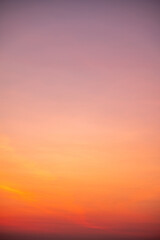 Beautiful sunrise sky with vibrant gradient orange and gold colors and soft blue, Clear atmosphere with wispy clouds. Peaceful, perfect for background and copy space, High resolution images Vertical © ISENGARD
