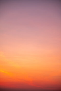 Beautiful sunrise sky with vibrant gradient orange and gold colors and soft blue, Clear atmosphere with wispy clouds. Peaceful, perfect for background and copy space, High resolution images Vertical