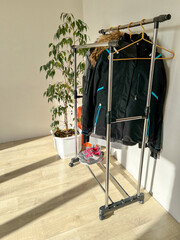 Clothing rack with jackets and sneakers in room