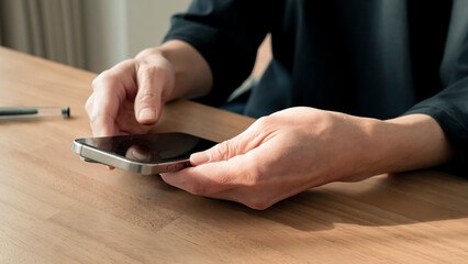 リラックスする男性の手元 スマートフォンとコーヒー ライフスタイル / Man using smartphone on wooden table, relaxed lifestyle