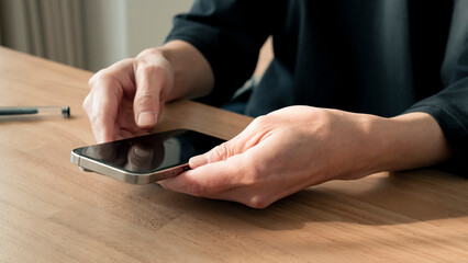リラックスする男性の手元 スマートフォンとコーヒー ライフスタイル / Man using smartphone on wooden table, relaxed lifestyle