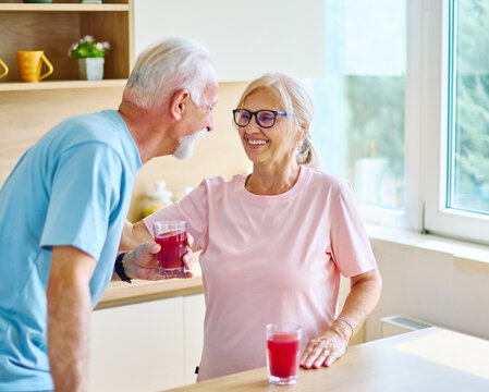 Happy senior couple enjoying breakfast nad healthy juice after the exercise  in the morning
