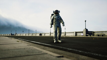 An astronaut stands on a wide road, surrounded by a unique urban setting. Towering structures and a cloudy sky create a surreal atmosphere in this mysterious midday scene. © icetray