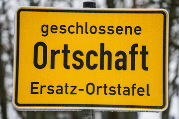 Gelbes Ersatz-Ortsschild markiert Beginn der geschlossenen Ortschaft