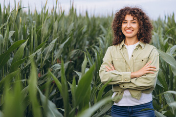 Agronomist woman working and posing in corn field with crossed arms