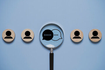 Customer feedback and audience insight concept with magnifying glass focusing on chat icons between user profiles. Market research, client communication analysis and consumer opinion strategy.
