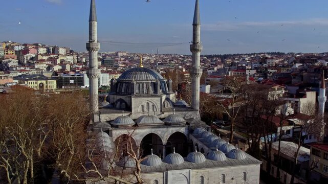 Aerial footage of the historic Yeni Valide Mosque located in &Uuml;sk&uuml;dar, Istanbul. Ottoman architecture, domes and minarets blend beautifully with the surrounding urban landscape.