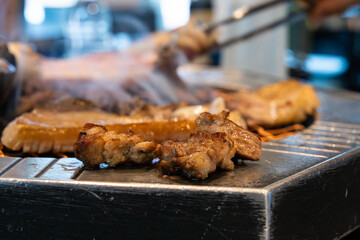 roasting pork belly on charcoal grill in a Korean restaurant