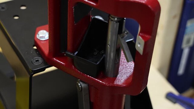 Hand placing a bullet casing into a reloading press for ammunition manufacturing