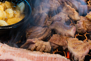 roasting pork belly on charcoal grill in a Korean restaurant