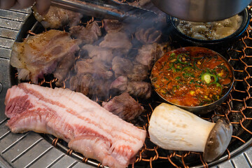 roasting pork belly on charcoal grill in a Korean restaurant