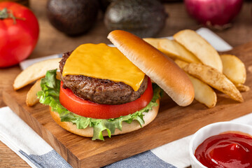 チーズをのせたビーフパティのハンバーガーとポテト