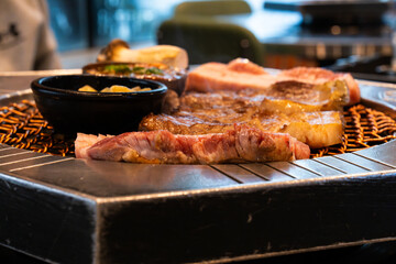 roasting pork belly on charcoal grill in a Korean restaurant