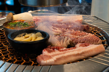 roasting pork belly on charcoal grill in a Korean restaurant