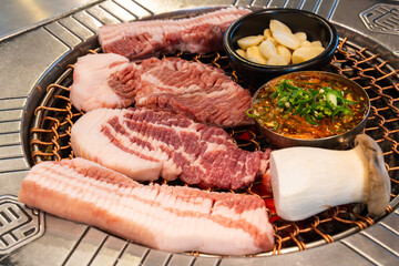 roasting pork belly on charcoal grill in a Korean restaurant