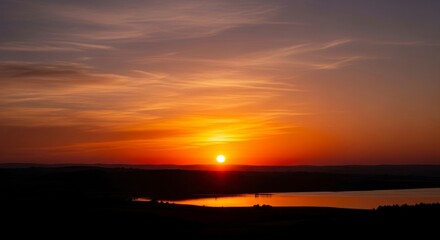 Obraz premium Serene Sunset over Calm Water Landscape.