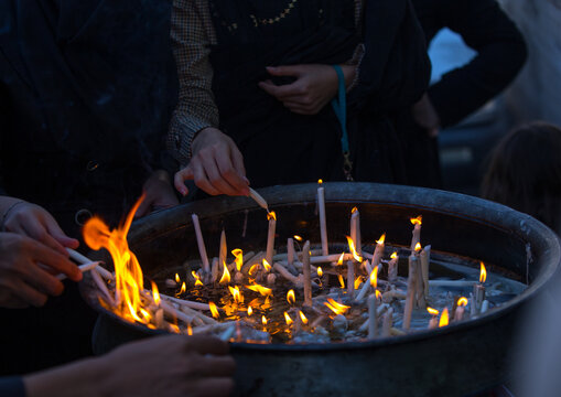 A man lights candles during chehel menbari to commemorate hussein, Lorestan, Khorramabad, Iran