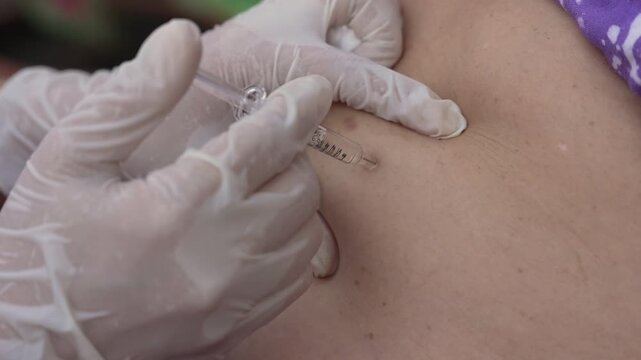 close up doctor is injecting enoxaparin injection to belly with syringe