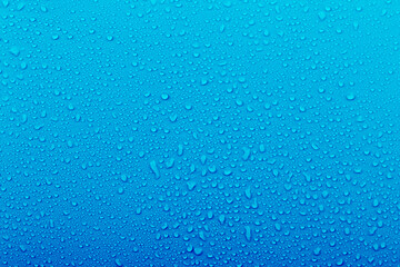 Water droplets on a blue background show textures and patterns created by moisture in the environment during a rainy day