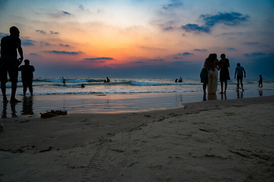 Sunset at Colva Goa beach in South India, silhouette of people swimming in Arabian Sea, tropical west coast, Asia, vacation destination