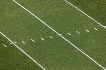 Fototapeta premium A view from above of an American Football grass field with field markings and yard lines. Generic football background image.