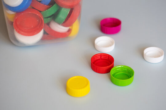 recycling of plastic. colorful lids caps and a canister with collected recyclables