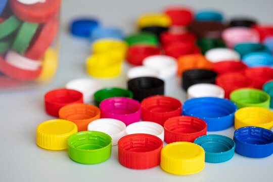 recycling of plastic. colorful lids caps and a canister with collected recyclables