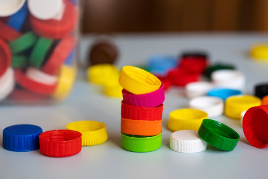 recycling of plastic. colorful lids caps and a canister with collected recyclables
