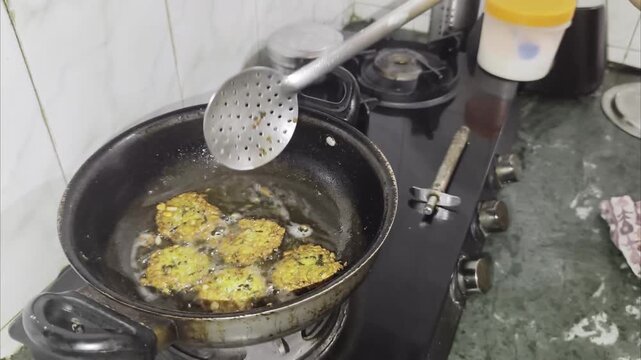 Dal vada deep frying in pan, chickpea lentils mix with onions, coriander 