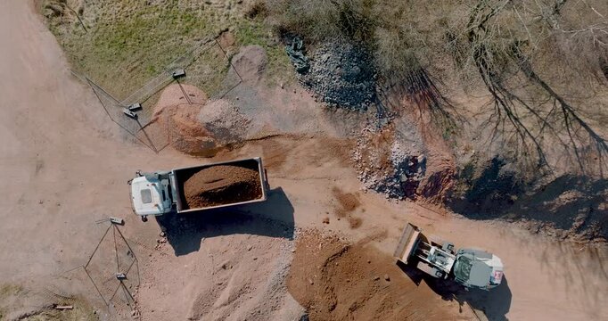 Aerial view of wheel loader and dump truck at construction site