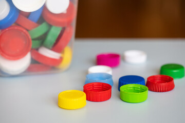 recycling of plastic. colorful lids caps and a canister with collected recyclables