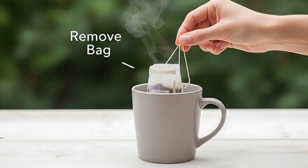 Hand removes steeping tea bag from a mug with steam rising.