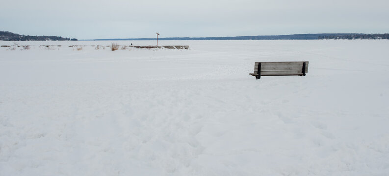 Winter Vista of a frozen Kempenfelt Bay with a lone walker on the breakwater