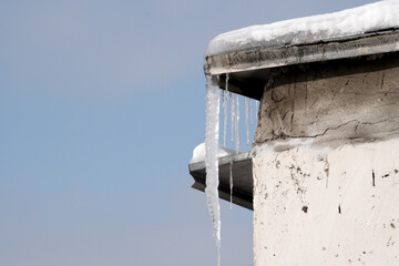 Icicles glisten under a clear blue sky on a winter afternoon