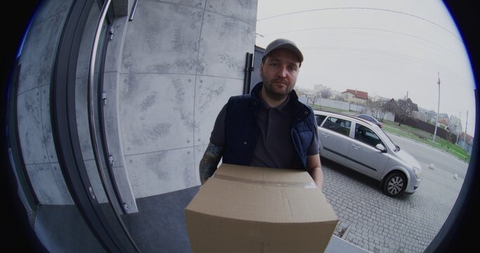 Male Courier Rings Bell and Leaves Large Box on Doorstep. Adult Man Captures Photo For Digital Proof of Delivery on Smartphone Then Walks Away. Represents Modern Contactless Service and Safety.