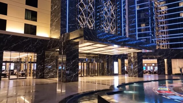 Modern Luxury Hotel Entrance at Night with Glowing Lights and Reflective Pavement