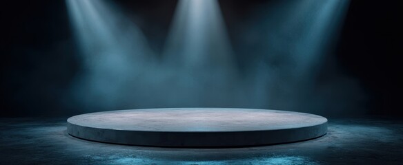 The stage empty round concrete platform bathed in dramatic moody overhead spotlights