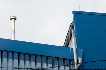 Industrial building with exhaust stack behind barbed wire