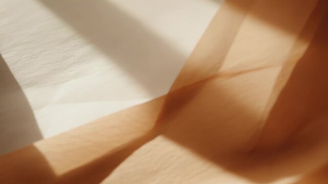 Soft beige and white fabric creating abstract patterns and textures as natural light casts gentle shadows and illuminates translucent layers of textile