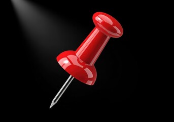 Brightly illuminated crimson office fastener rests against a deep black background