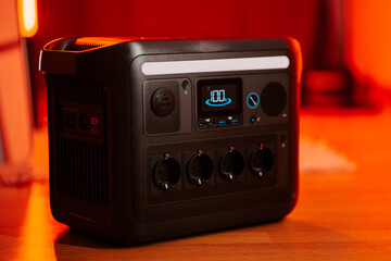 Portable power station with display and multiple outlets in indoor setting during evening hours