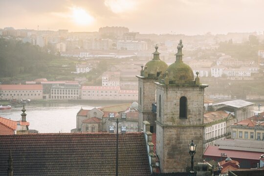 Golden light bathes the Porto skyline as the sun sets over the Douro River. Historic buildings and rooftops come alive, showcasing the beauty of Porto&rsquo;s rich cultural heritage and vibrant community