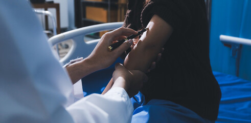 Obraz premium Doctor in hospital using manual blood pressure monitor to measure woman patient blood pressure and pulse.